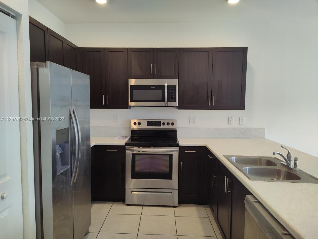 18232 Southwest 148th Road Miami, FL 33187 - Photo 12 of 32 a kitchen with a sink and steel stainless steel appliances
