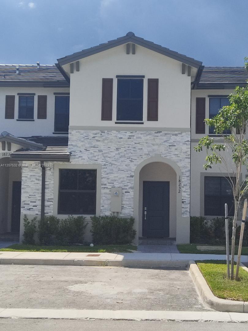 18232 Southwest 148th Road Miami, FL 33187 - Photo 2 of 32 a front view of a house with a yard and garage