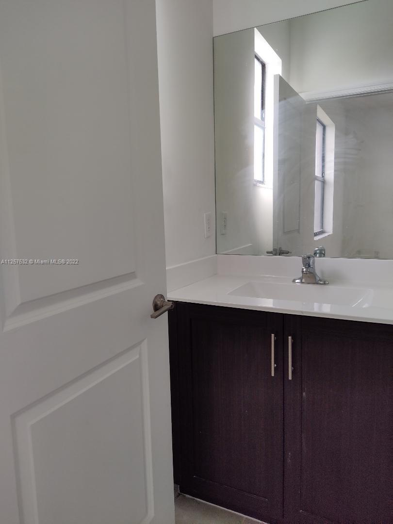 18232 Southwest 148th Road Miami, FL 33187 - Photo 22 of 32 a bathroom with a sink and a mirror