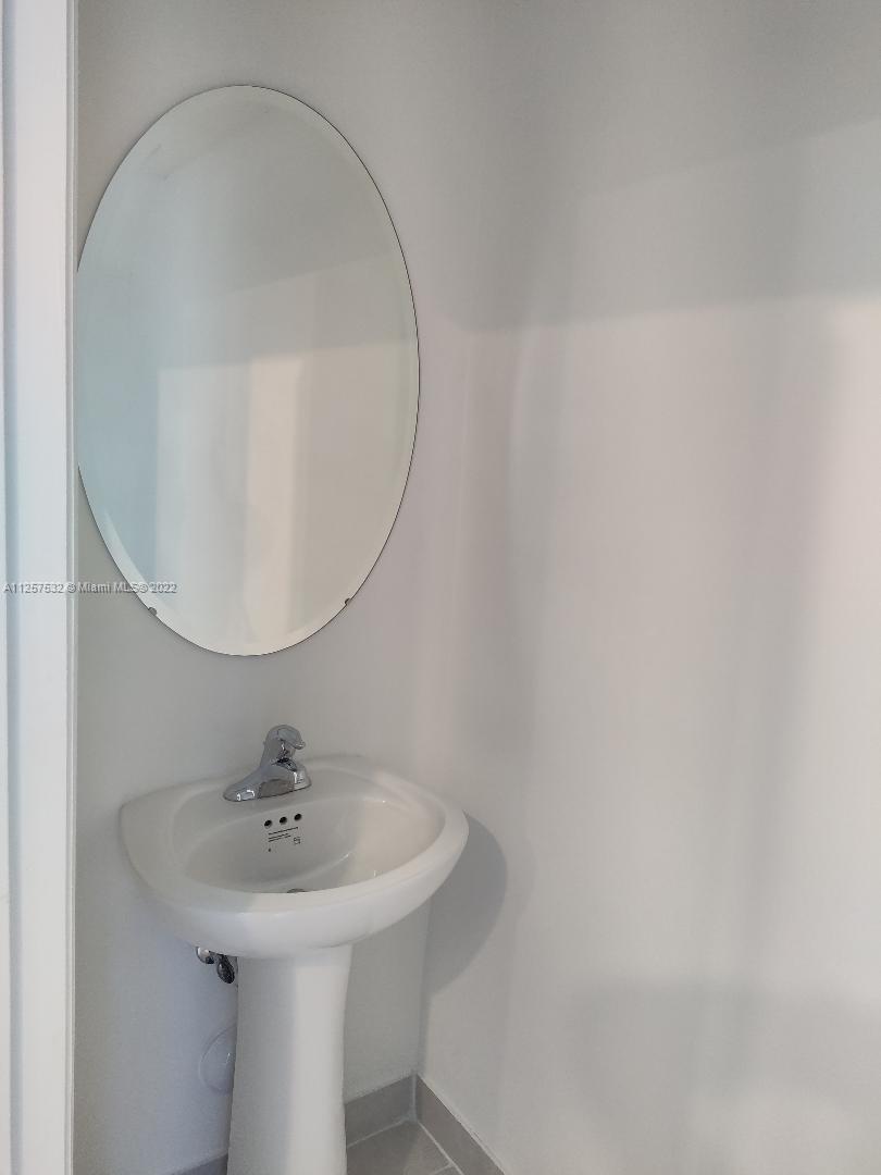 18232 Southwest 148th Road Miami, FL 33187 - Photo 23 of 32 a bathroom with a sink a mirror and toilet