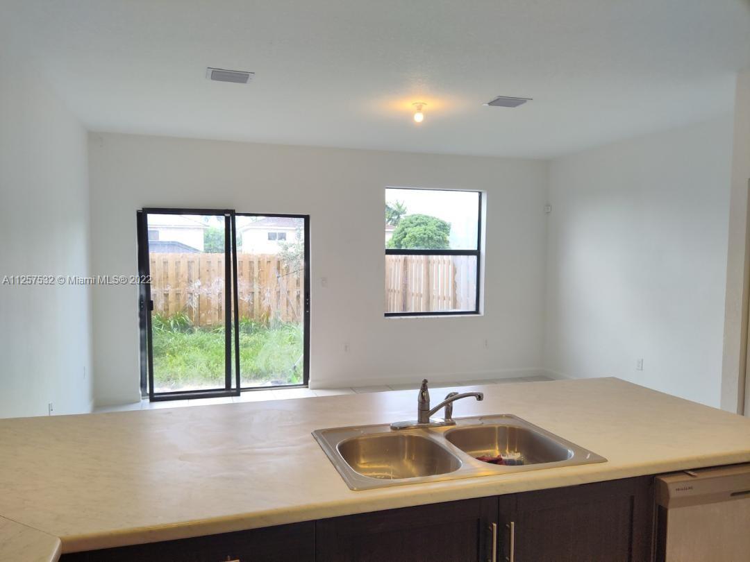 18232 Southwest 148th Road Miami, FL 33187 - Photo 6 of 32 a kitchen with a sink and a window