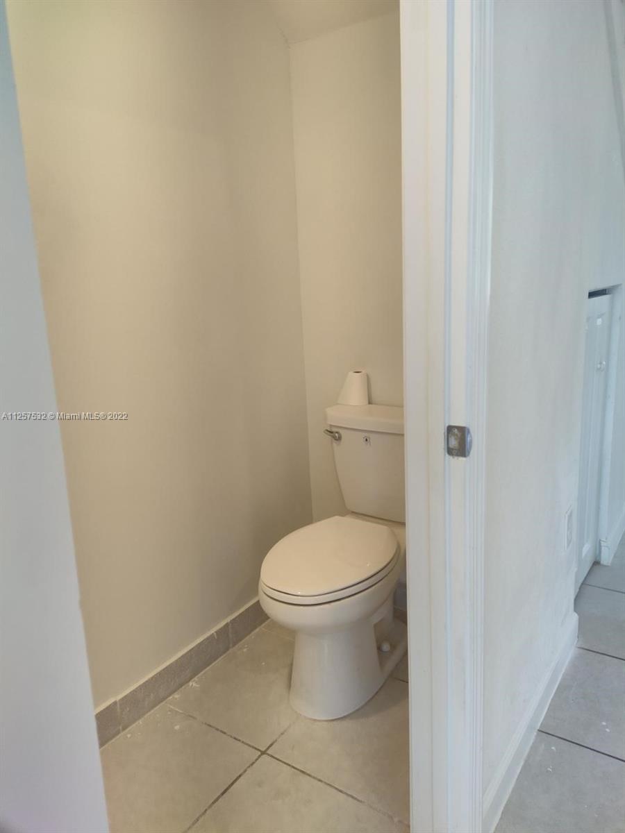 18232 Southwest 148th Road Miami, FL 33187 - Photo 9 of 32 a white toilet sitting next to a white wall