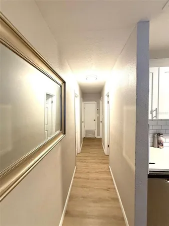 a view of a hallway with wooden floor and staircase