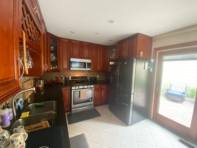 a kitchen with stainless steel appliances granite countertop a refrigerator and a sink