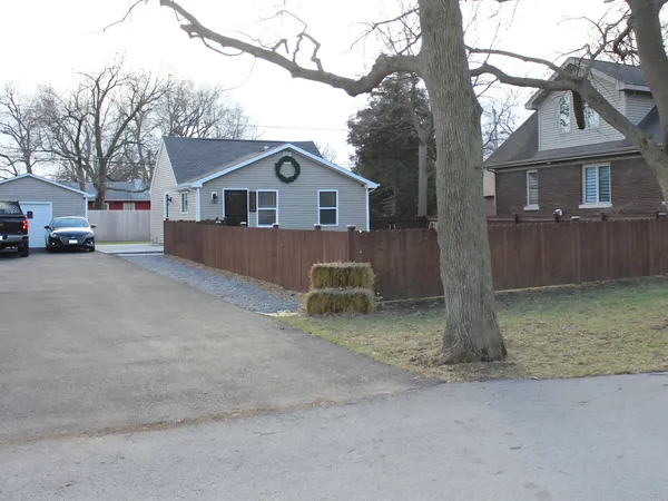 a view of a house with a yard and large tree
