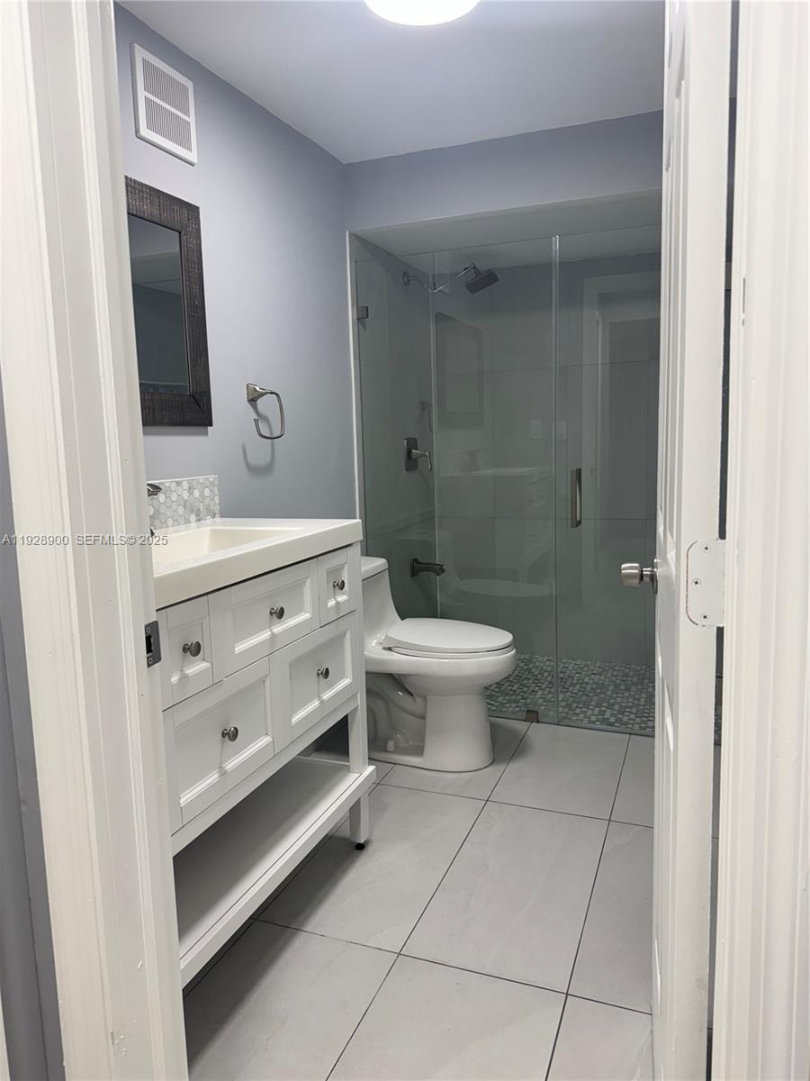 881 Hialeah Drive Hialeah, FL 33010 - Photo 18 of 36 a bathroom with a sink a toilet a mirror and shower