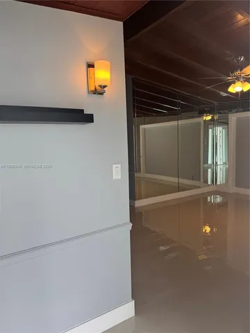 a view of an empty room with a chandelier fan