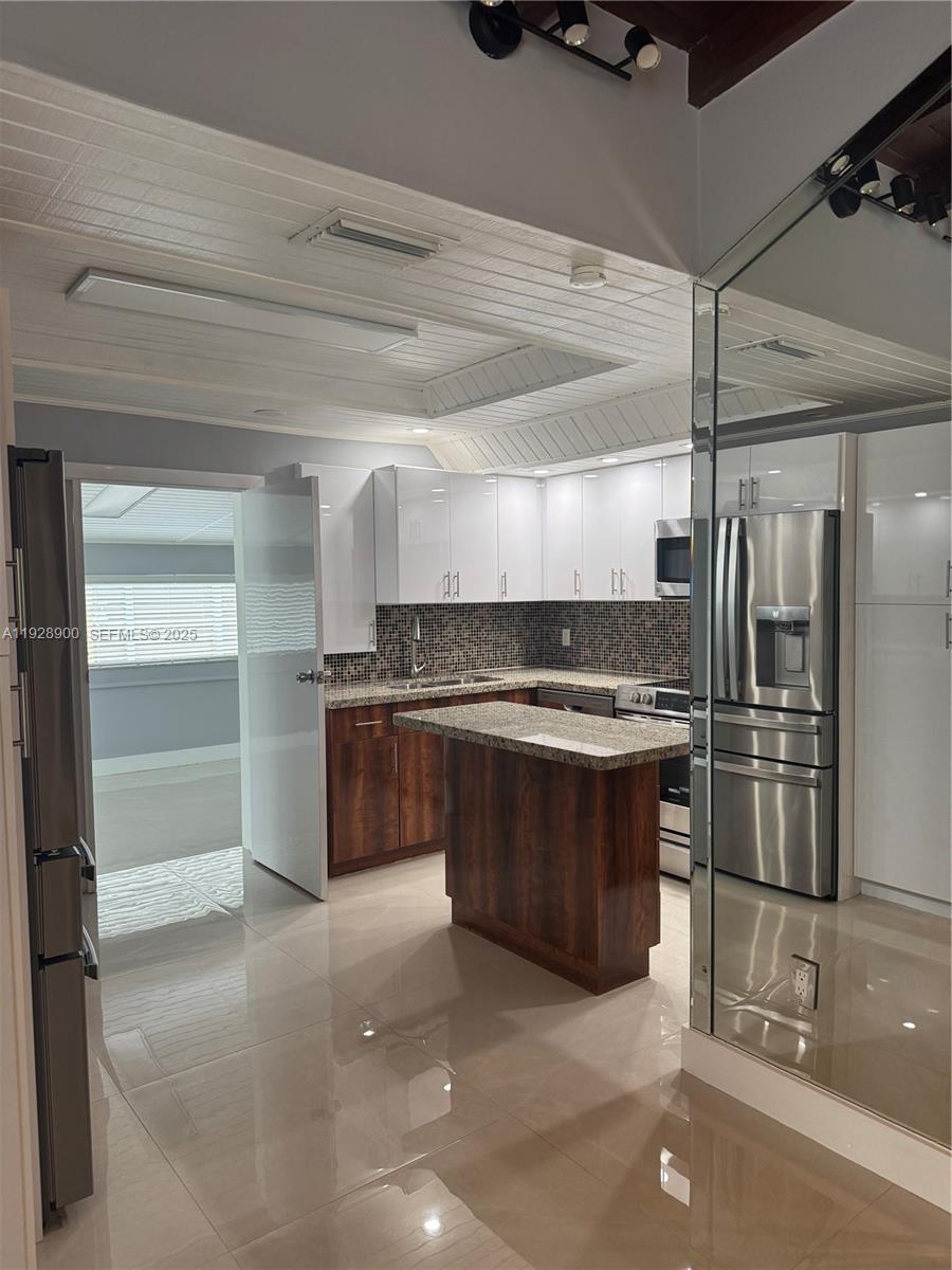 881 Hialeah Drive Hialeah, FL 33010 - Photo 4 of 36 a kitchen with stainless steel appliances kitchen island granite countertop a refrigerator and a sink