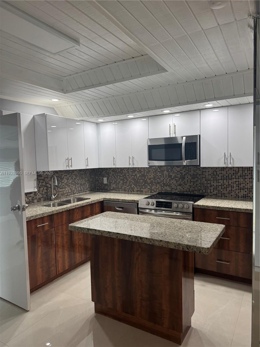 881 Hialeah Drive Hialeah, FL 33010 - Photo 5 of 36 a kitchen with stainless steel appliances granite countertop a sink and a stove