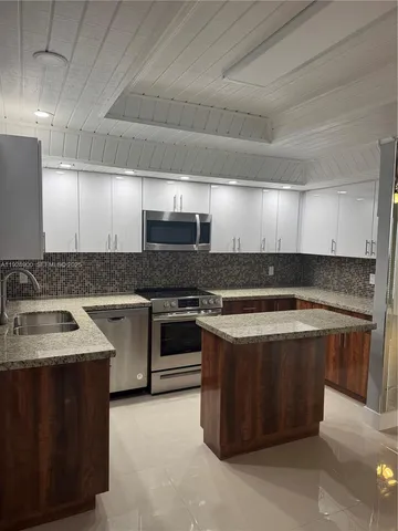 a kitchen with stainless steel appliances wooden cabinets and a stove top oven