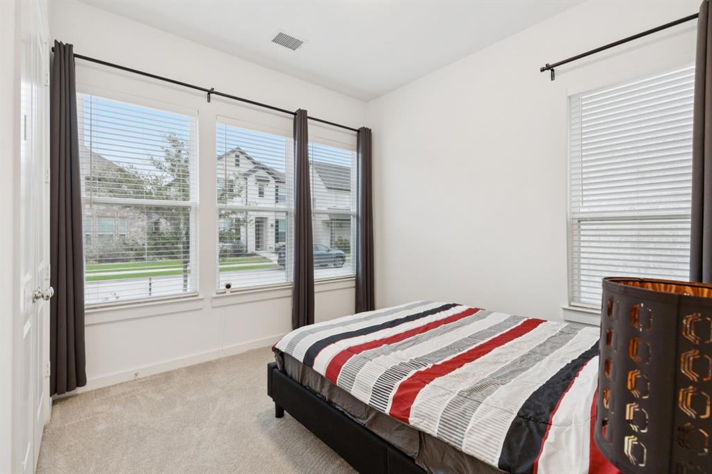 547 Embargo Drive Fate, TX 75189 - Photo 16 of 36 a bedroom with a bed and a large window