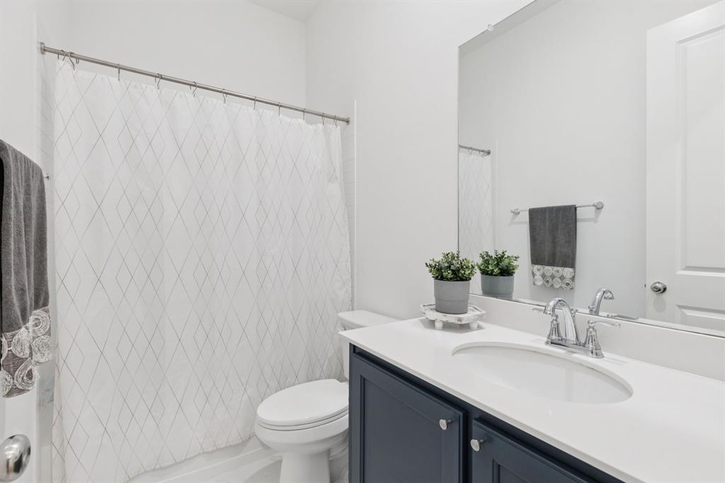 547 Embargo Drive Fate, TX 75189 - Photo 17 of 36 a bathroom with a granite countertop sink and a mirror