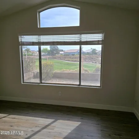 an empty room with wooden floor and a window