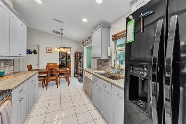 a kitchen with stainless steel appliances granite countertop a refrigerator and a stove top oven