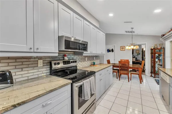 a kitchen with granite countertop a sink a counter top space appliances and cabinets