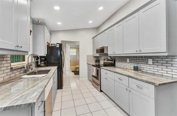 a kitchen with white cabinets sink and stainless steel appliances