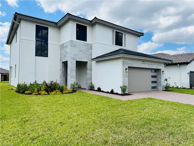 a front view of a house with a yard and garage