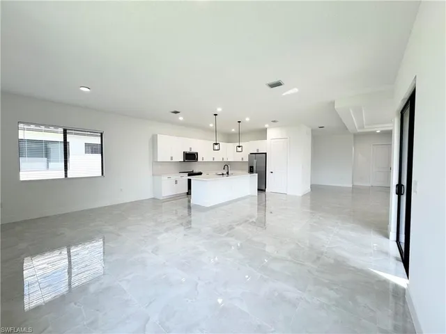 a kitchen with stainless steel appliances kitchen island granite countertop a sink a stove and a refrigerator