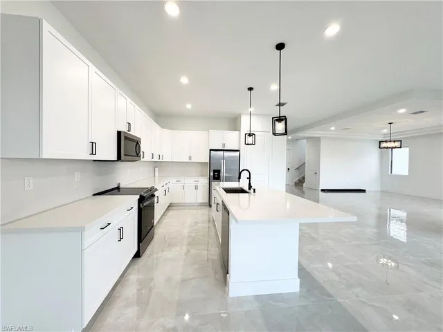 a large white kitchen with stainless steel appliances
