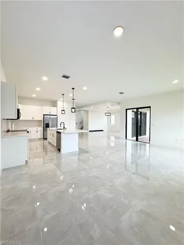 a kitchen with stainless steel appliances granite countertop a sink a stove and a refrigerator