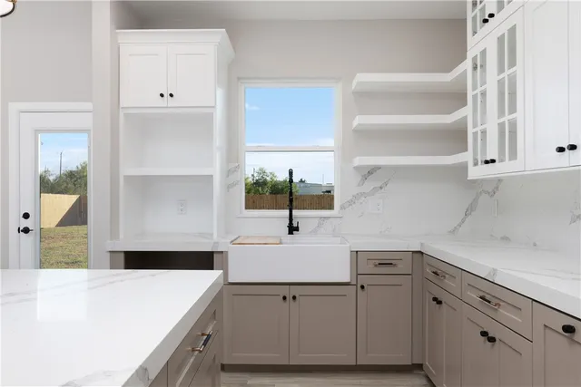 a kitchen with a sink dishwasher and white cabinets