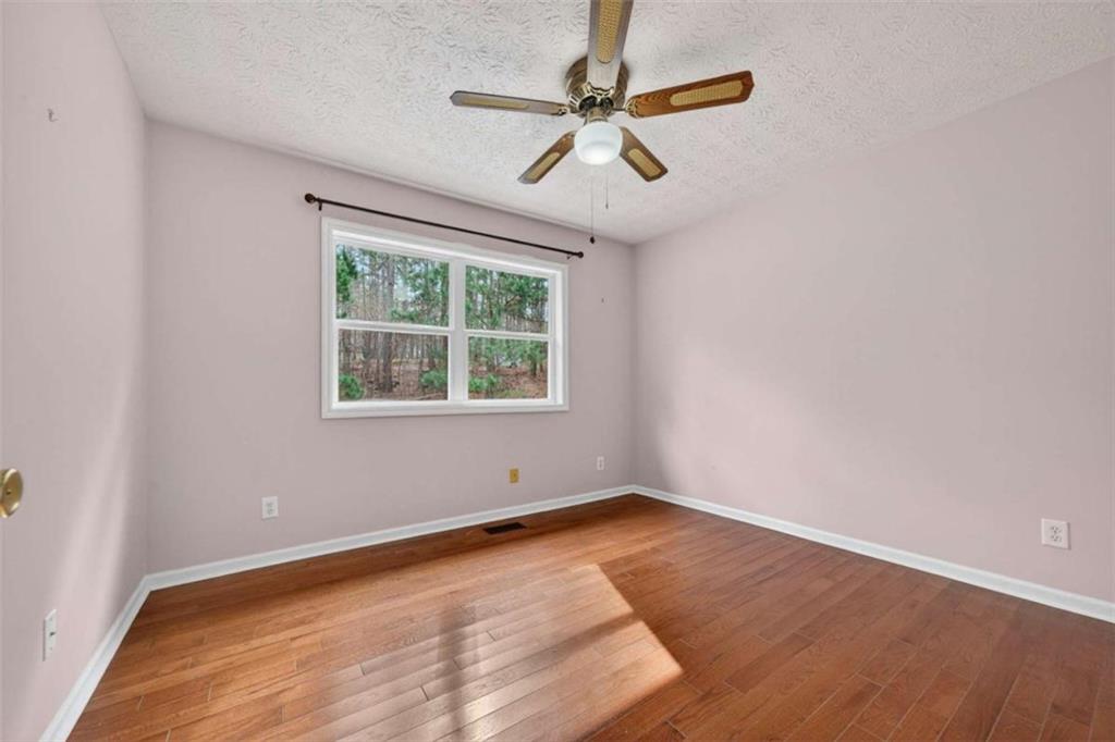 1951 Swords Trail Buckhead, GA 30625 - Photo 31 of 102 an empty room with wooden floor ceiling fan and windows