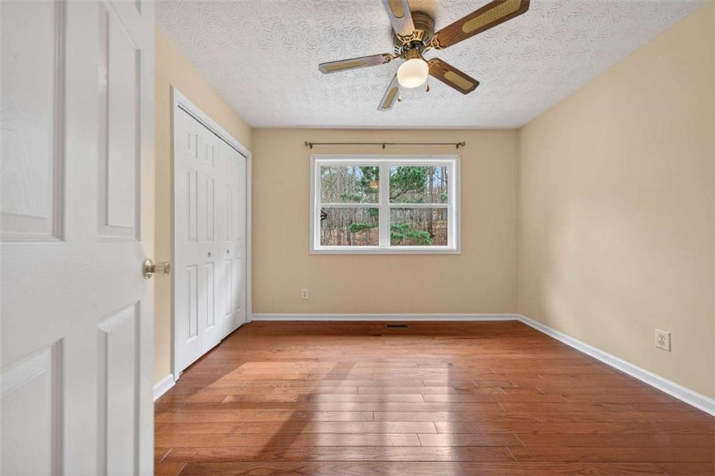 1951 Swords Trail Buckhead, GA 30625 - Photo 41 of 102 an empty room with wooden floor chandelier fan and windows