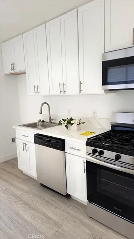 a kitchen with granite countertop white cabinets and white appliances