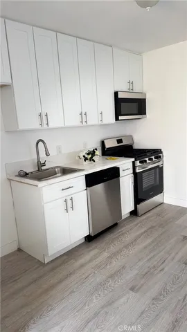 a kitchen with stainless steel appliances granite countertop a sink and a stove top oven