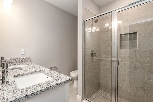 a bathroom with a granite countertop sink and shower