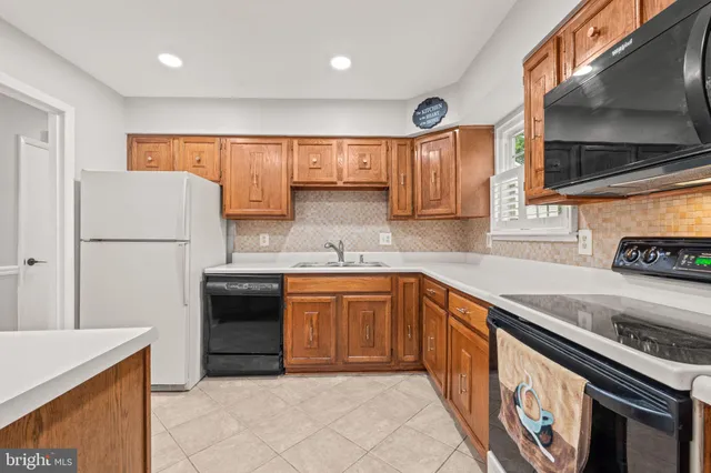 a kitchen with granite countertop a refrigerator stove top oven and sink