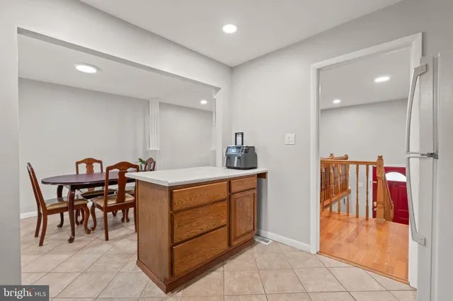 a kitchen with stainless steel appliances granite countertop a table chairs and a refrigerator