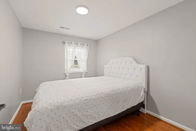 a large bed sitting in a bedroom next to a window