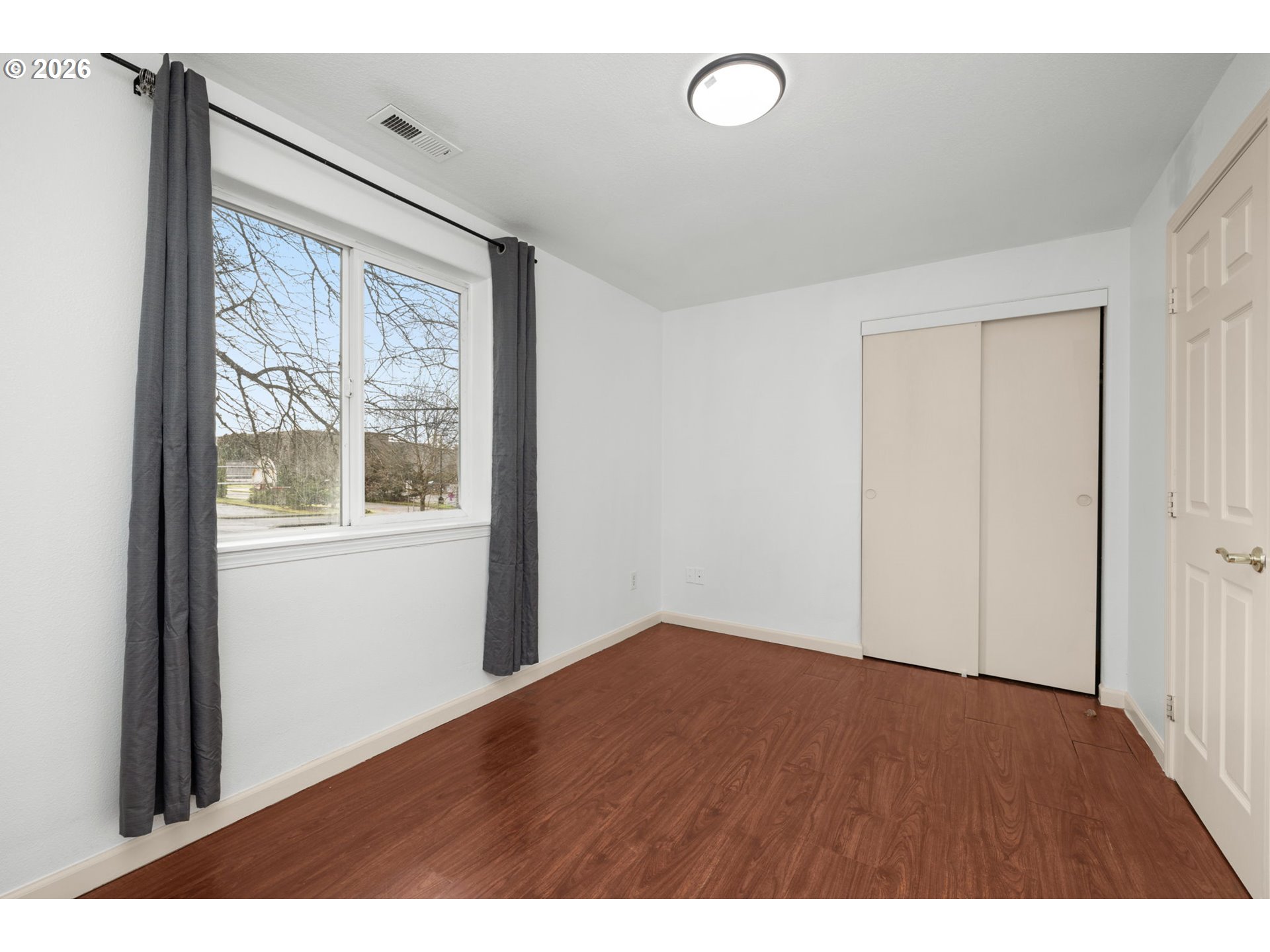 8704 Southeast Rhone Street Portland, OR 97266 - Photo 17 of 24 a view of empty room with wooden floor and fan