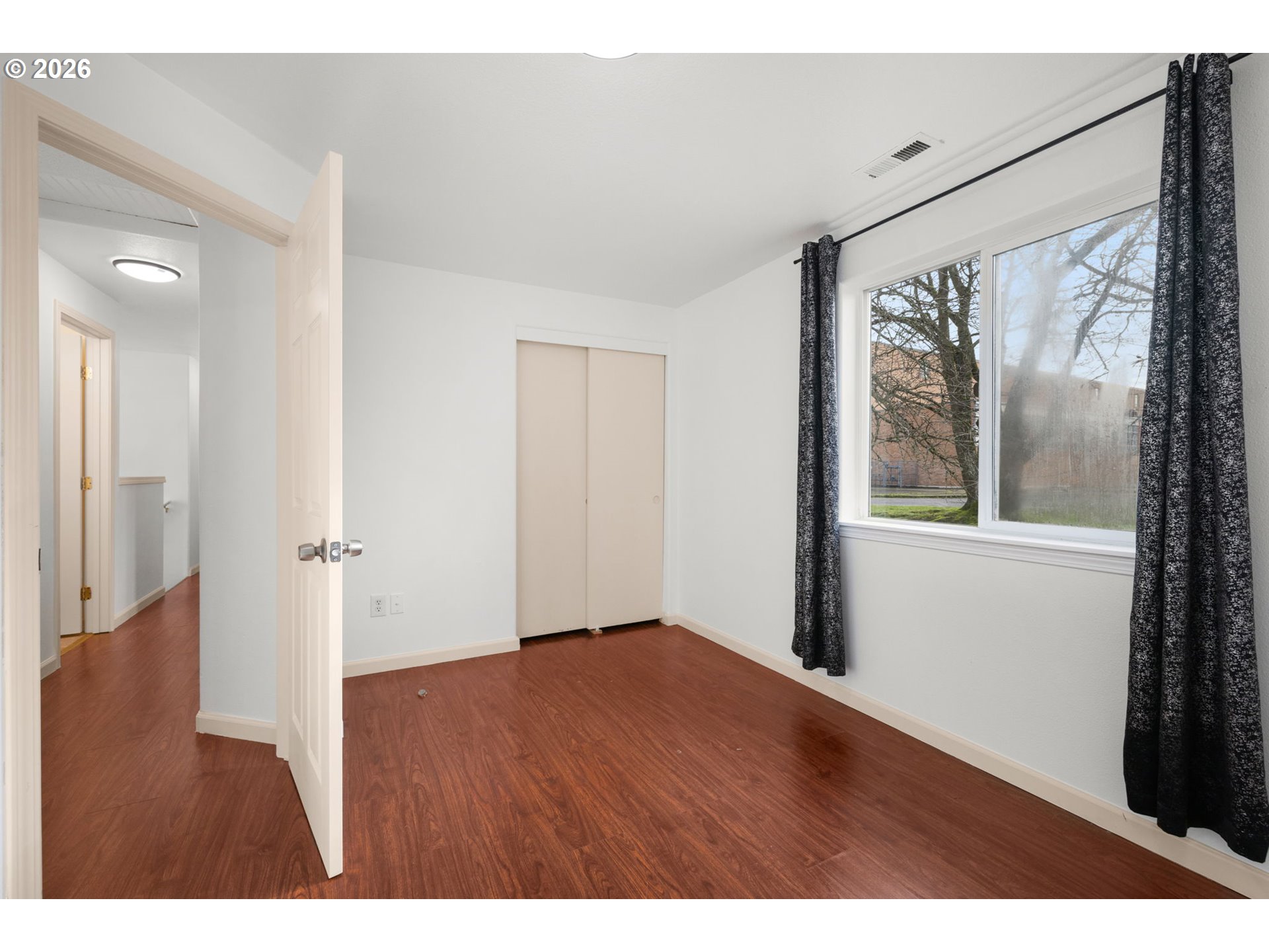 8704 Southeast Rhone Street Portland, OR 97266 - Photo 18 of 24 a view of an empty room with wooden floor and a window