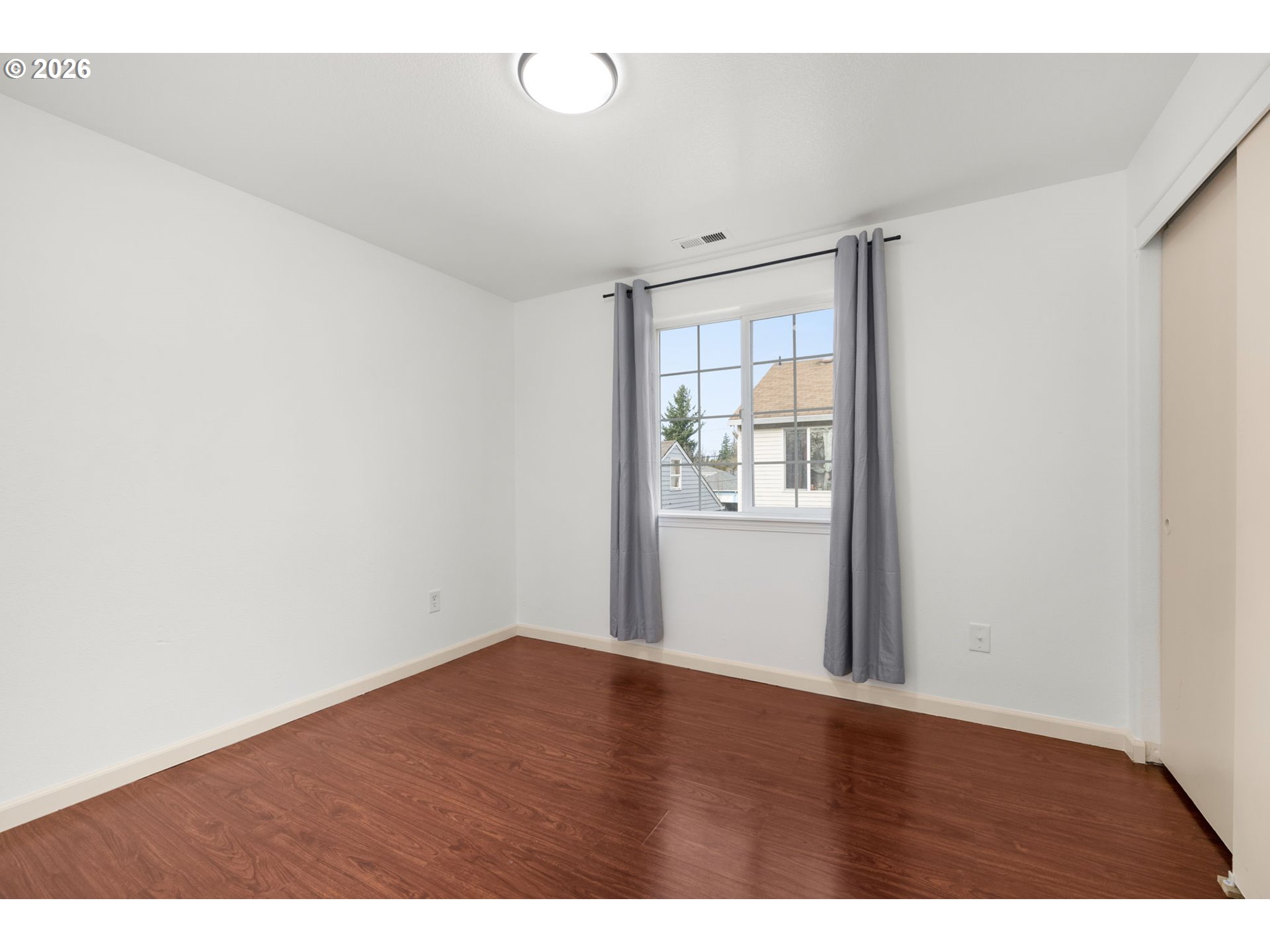 8704 Southeast Rhone Street Portland, OR 97266 - Photo 19 of 24 a view of an empty room with wooden floor and a window