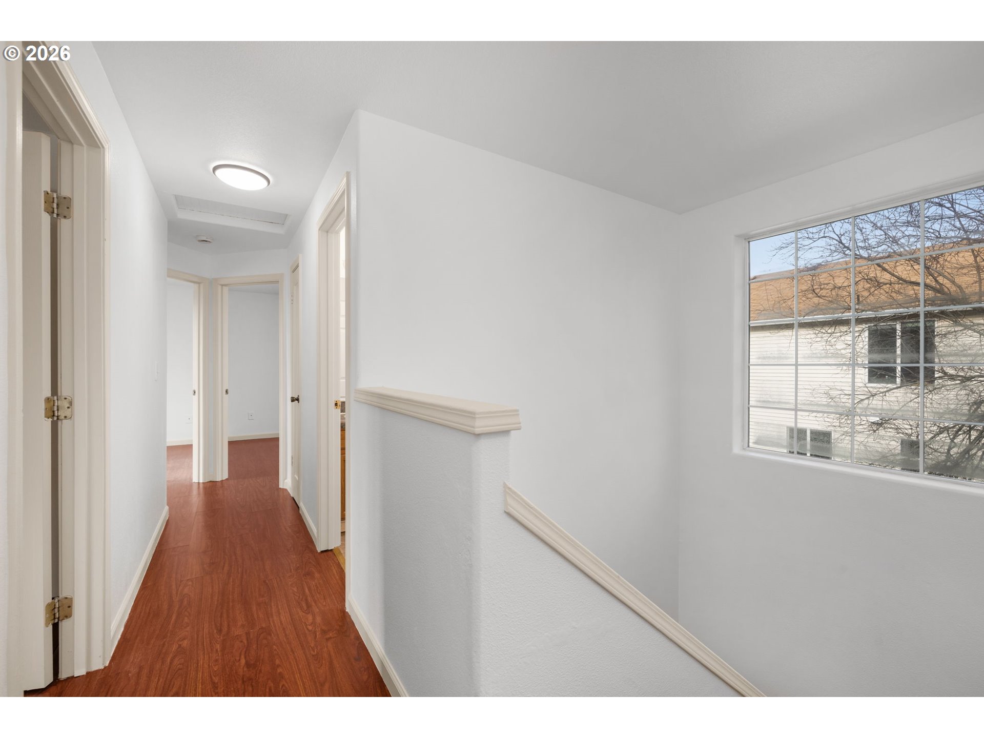 8704 Southeast Rhone Street Portland, OR 97266 - Photo 21 of 24 a view of a hallway with wooden floor and windows