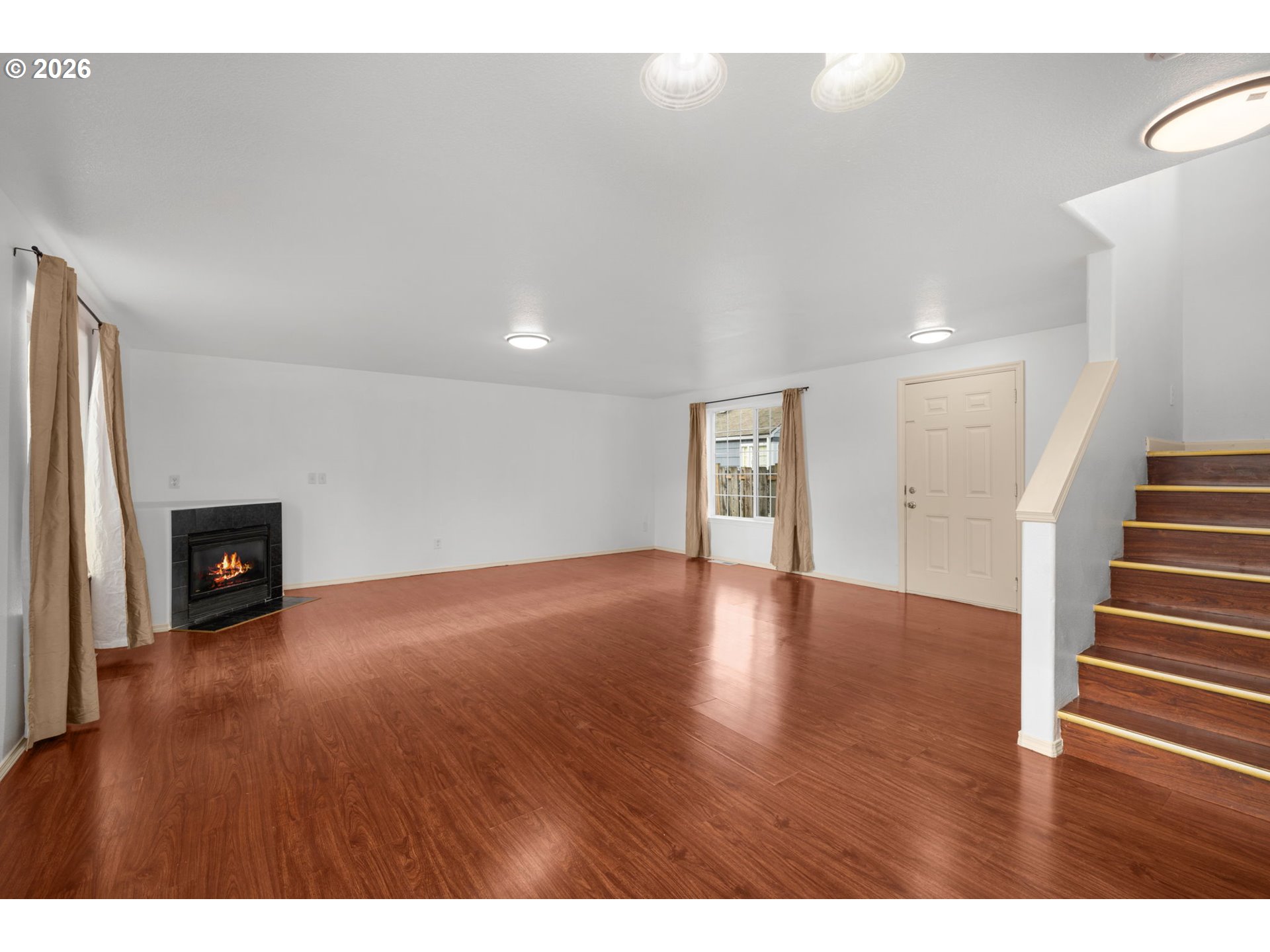 8704 Southeast Rhone Street Portland, OR 97266 - Photo 5 of 24 a view of an empty room with wooden floor and a fireplace