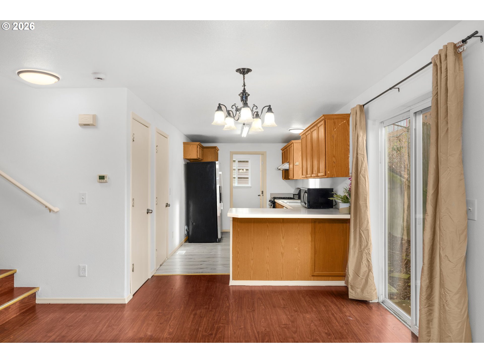 8704 Southeast Rhone Street Portland, OR 97266 - Photo 8 of 24 a living room with stainless steel appliances kitchen island granite countertop furniture and a view of kitchen