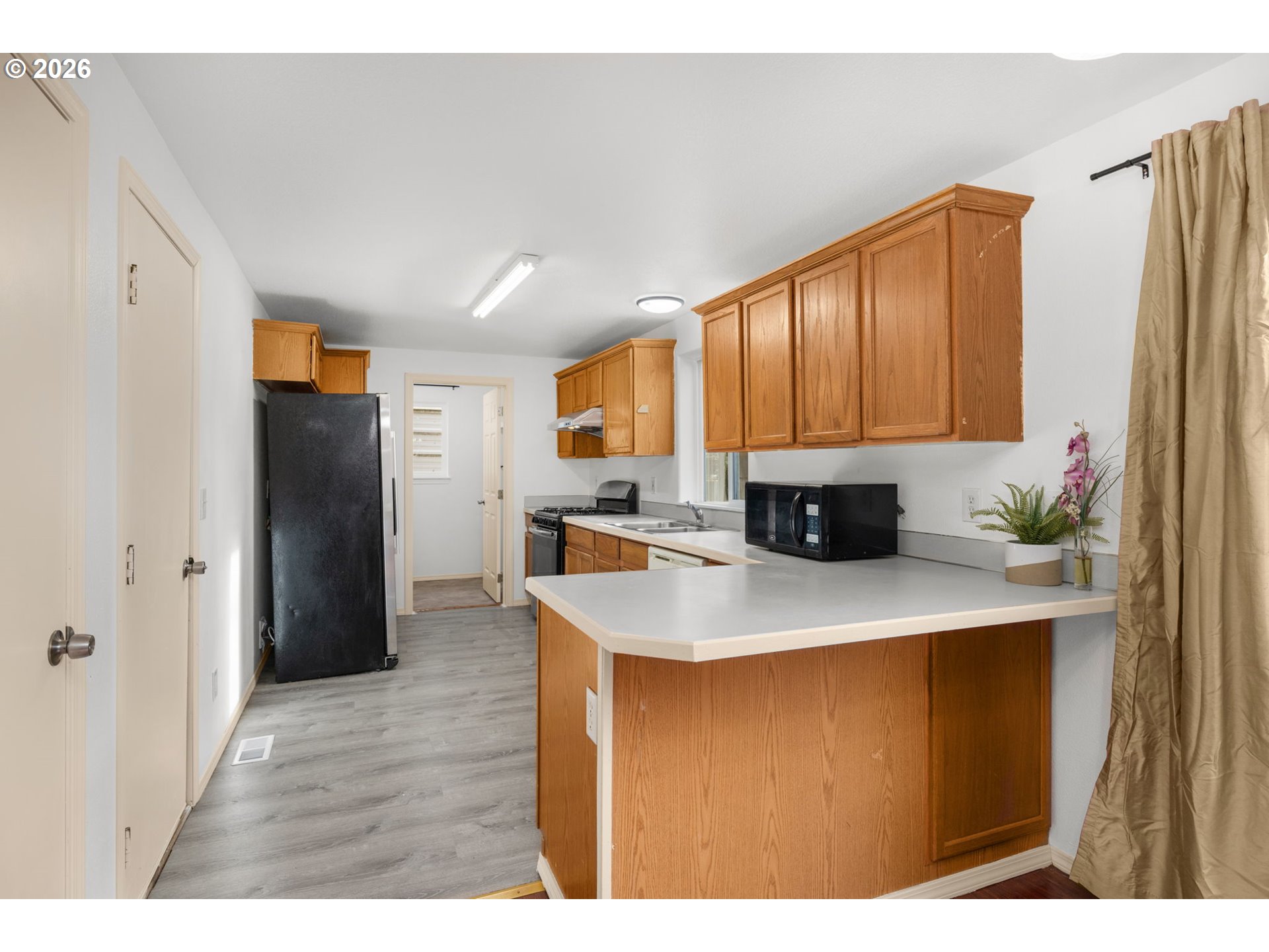 8704 Southeast Rhone Street Portland, OR 97266 - Photo 9 of 24 a kitchen with stainless steel appliances granite countertop a refrigerator a sink dishwasher and a stove with wooden floor