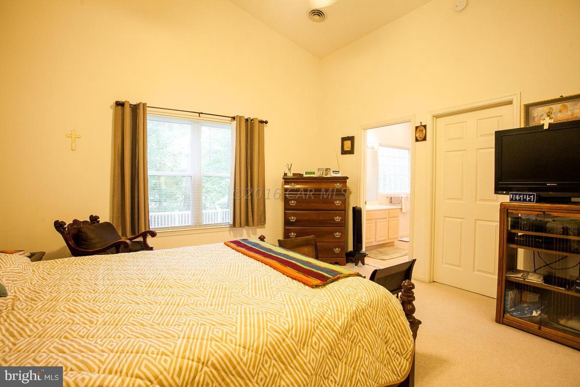 133 Pinehurst Road Berlin, MD 21811 - Photo 73 of 112 a bedroom with a bed table and a flat screen tv