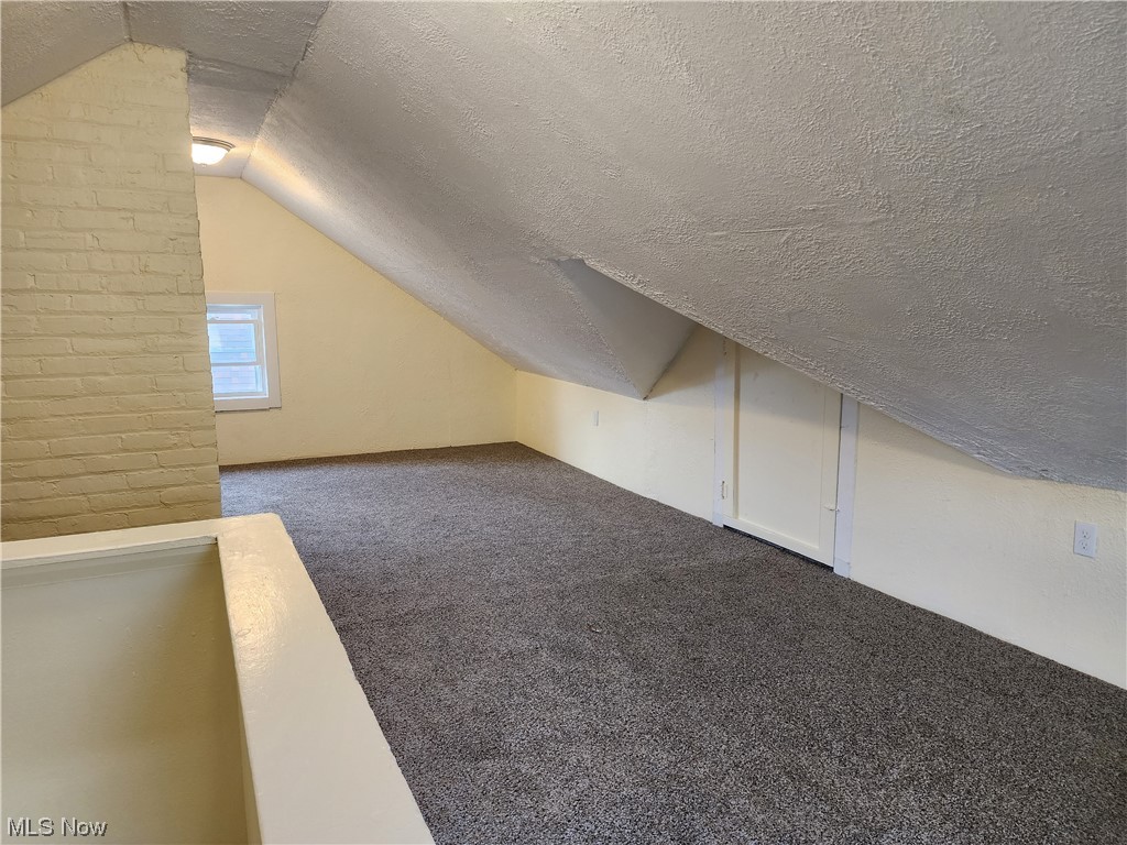17814 Crestland Road Cleveland, OH 44119 - Photo 27 of 49 Bonus room,dark colored carpet, and a textured ceiling