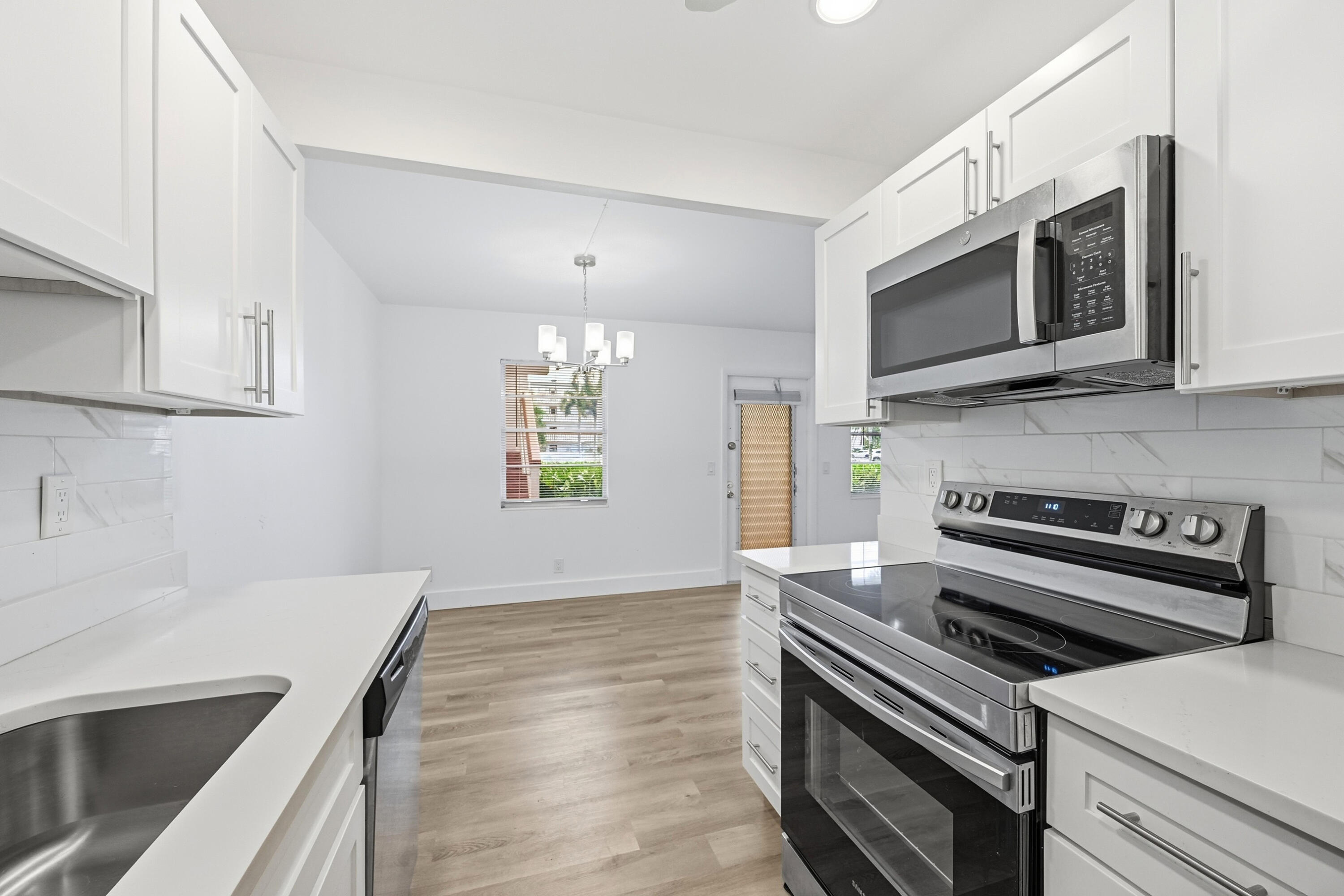 1043 Cornwall C Boca Raton, FL 33434 - Photo 10 of 34 a kitchen with stainless steel appliances and wooden cabinets