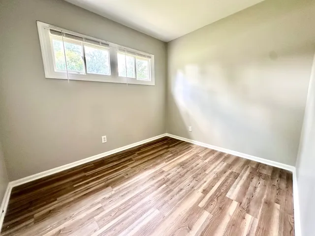 a view of a room with wooden floor and a window