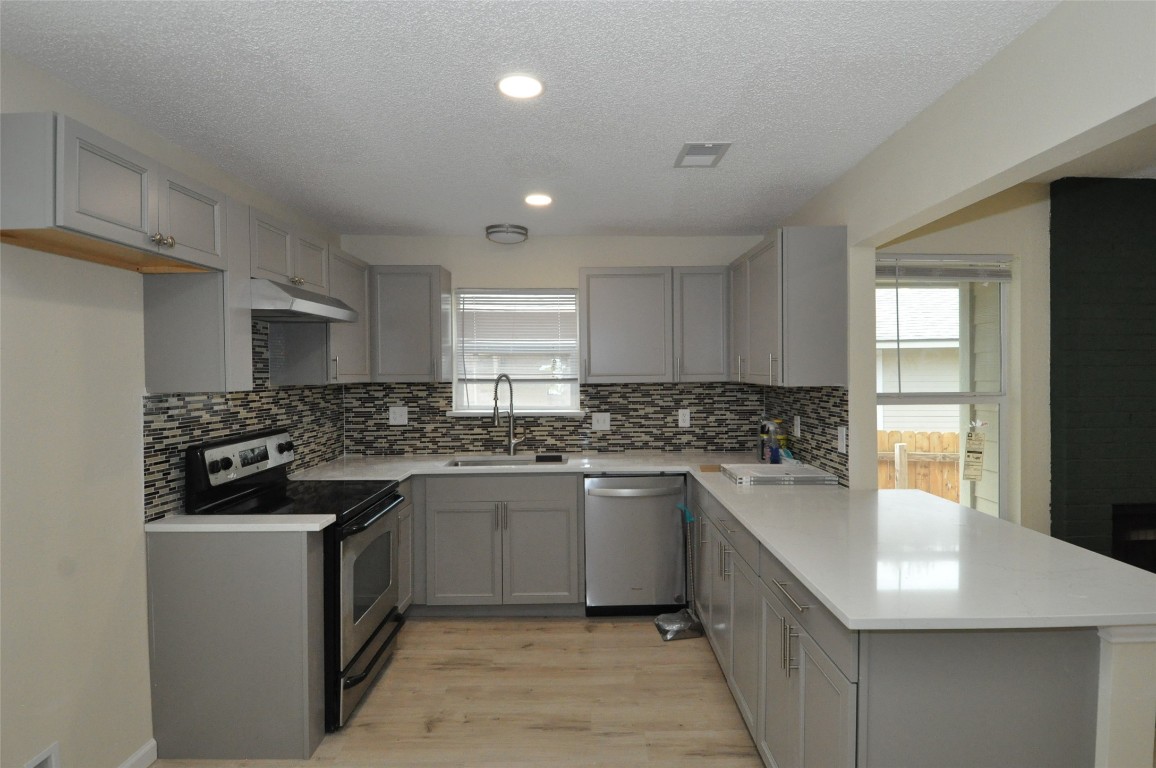 9910 Brasher Drive, Unit B Austin, TX 78748 - Photo 2 of 11 a kitchen with a sink stove and cabinets