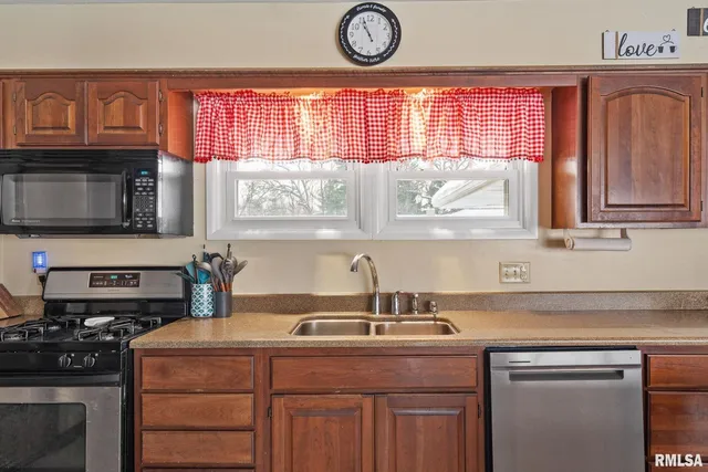 a kitchen with kitchen island granite countertop a sink a stove and cabinets