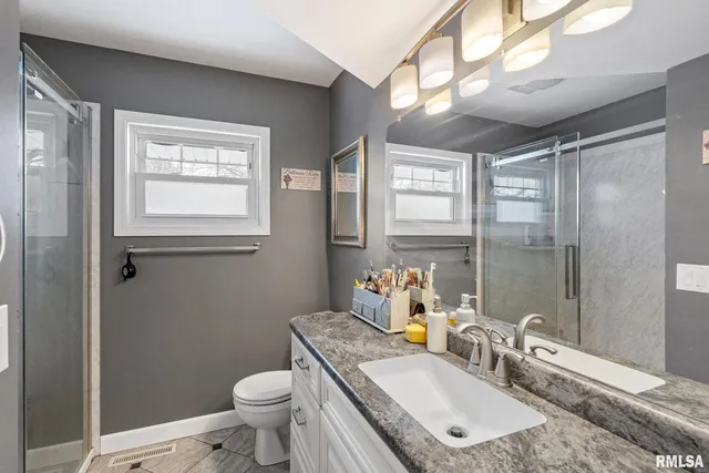 a bathroom with a granite countertop sink toilet and shower