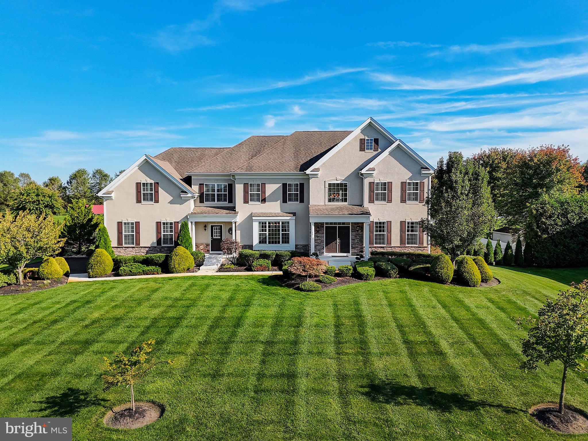 a view of a house with a big yard and large trees