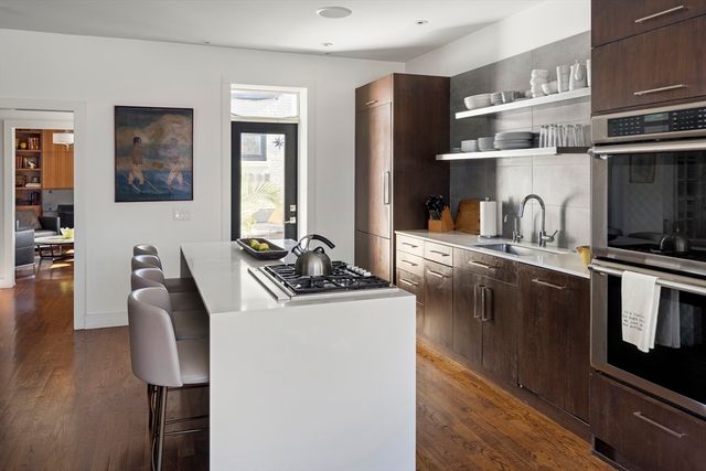 a kitchen with stainless steel appliances granite countertop a sink a stove and a refrigerator