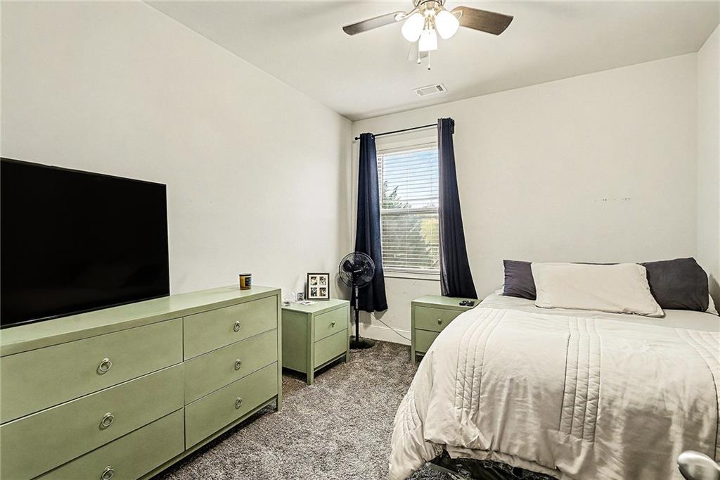 7284 Demeter Atlanta, GA 30349 - Photo 27 of 33 a bedroom with a large bed and a flat tv screen on a dresser